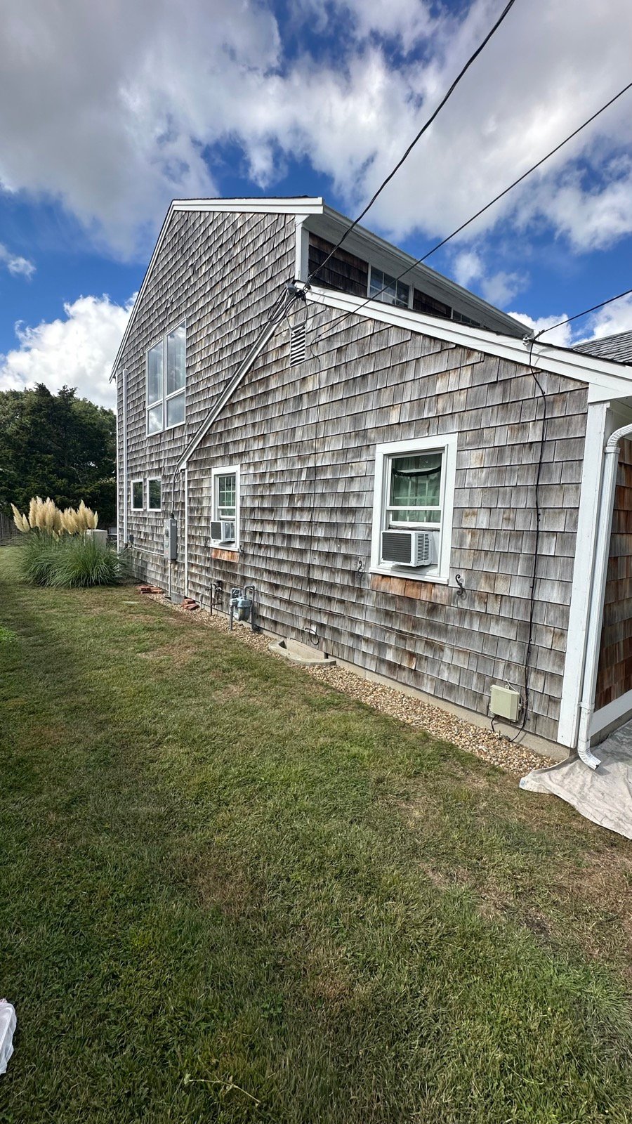 Weathered cedar shingle siding on a Dennis, MA home before replacement by West Mountain Construction