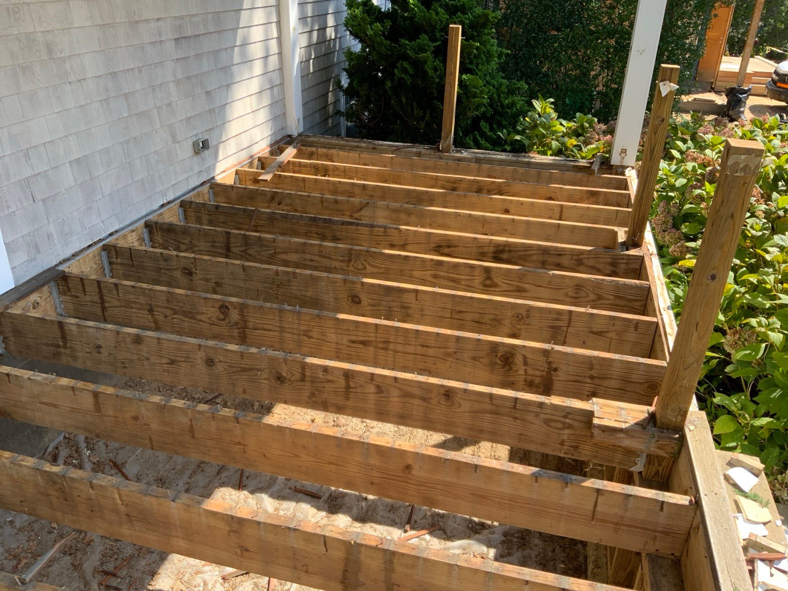 Deck framing and joists during a deck rebuild in Dennis, MA by West Mountain Construction